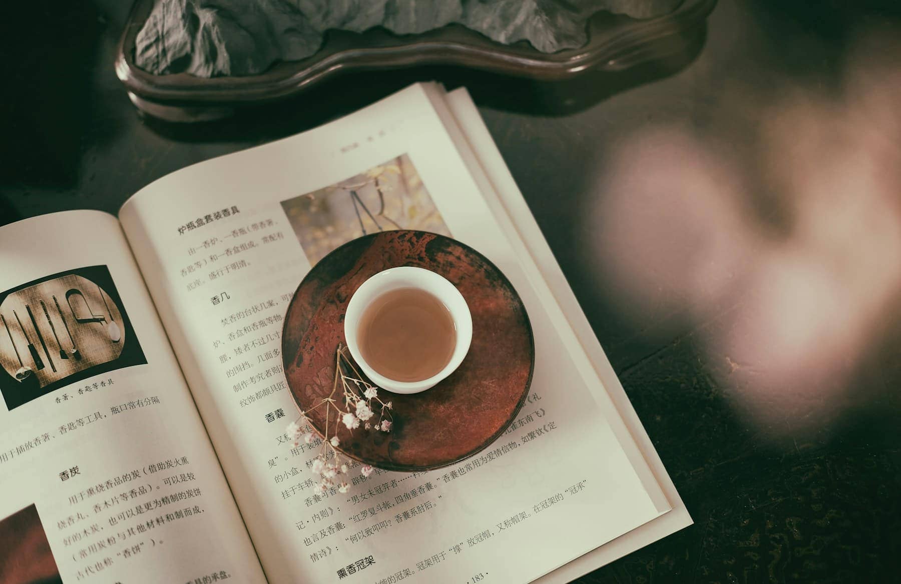 Une tasse de café posée sur un livre, sur une table en bois