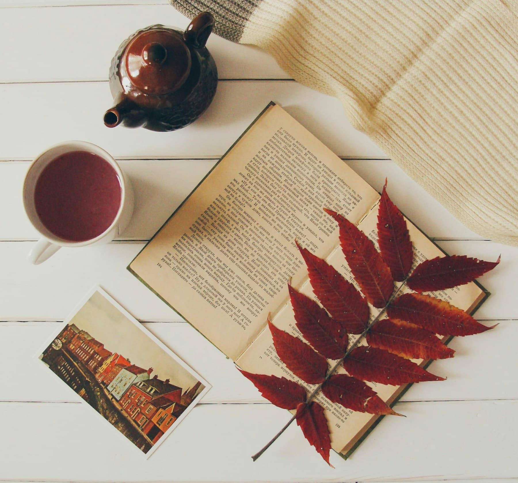 Une théière, une tasse et un livre posés sur une table